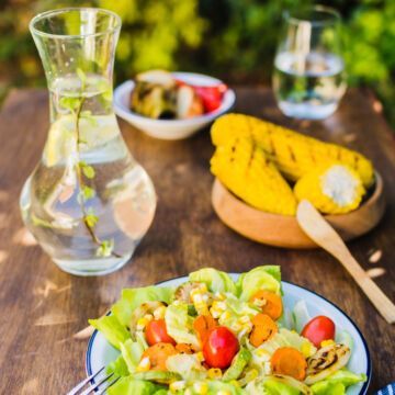 Repas équilibré avec salade maïs et carafe d'eau. Freepik