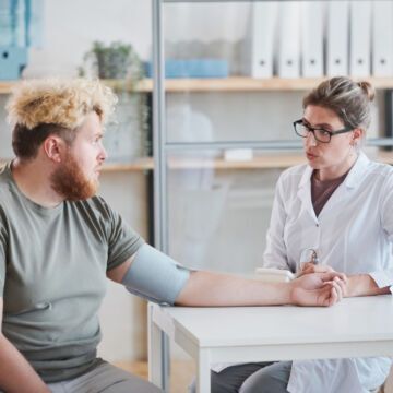 Homme qui consulte une professionnelle de santé pour apprendre à mieux gérer sa charge mentale.