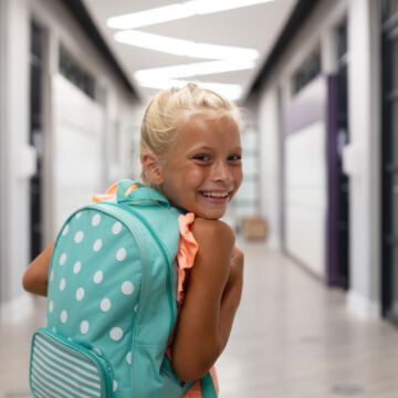 Enfant qui sourit dans un couloir. Freepik