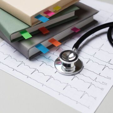 Stéthoscope posé sur une pile de dossier pour symboliser la médecine et la CPAM. Freepik