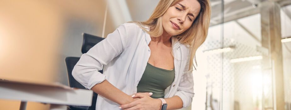 Femme qui se serre le ventre pendant une intoxication alimentaire.