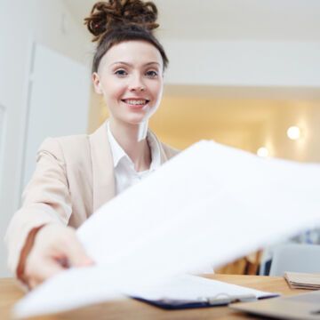 Jeune femme qui tend des documents pour s'inscrire à une caisse primaire d'assurance maladie. Freepik
