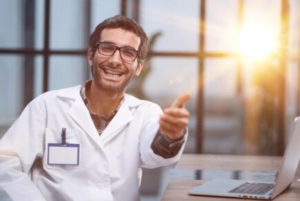 Jeune médecin heureux qui fait un pouce en l'air et pratique le tiers payant pour éviter un reste à charge à ses patients.