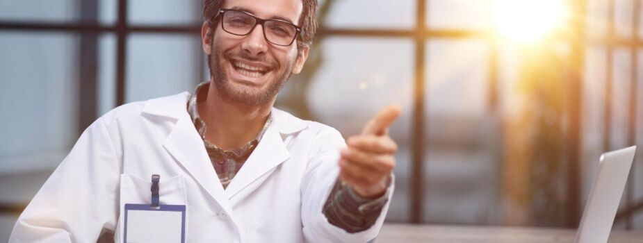 Jeune médecin heureux qui fait un pouce en l'air et pratique le tiers payant pour éviter un reste à charge à ses patients.