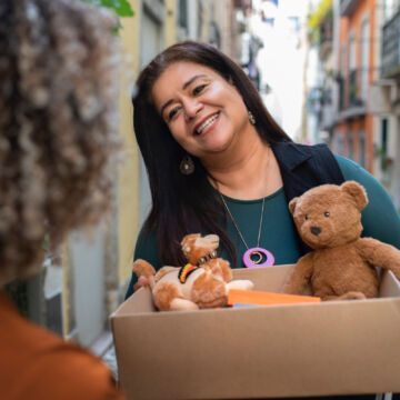 Femme qui distribue des jouets et des produits de première nécessité à celles et ceux qui en ont besoin en fin d'année.