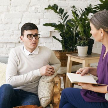 Jeune homme en consultation chez une psychologue suite à des symptômes dépressifs.